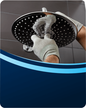 Plumber fitting a new rain shower head in a bathroom