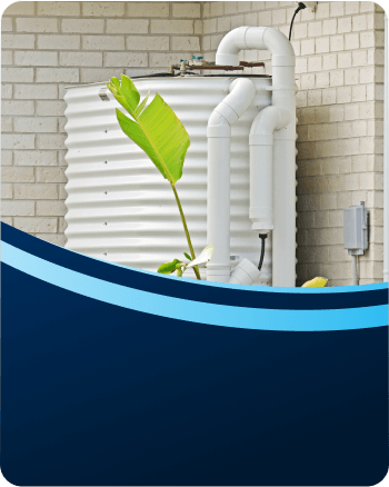 Rainwater tank and pump installed beside a home