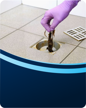 Plumber clearing a blocked floor drain